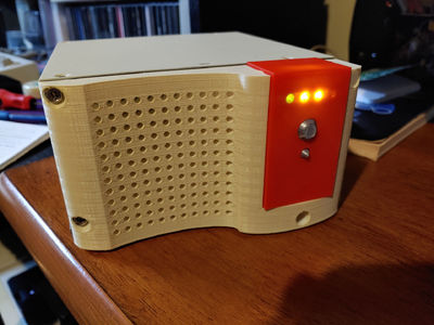 A biege and red box with LEDs and buttons.