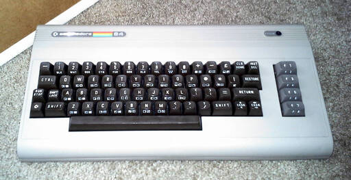 A beige computer built into a keyboard with dark brown keys