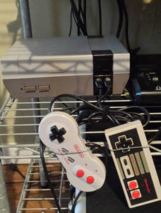 NES with blank cartridge door, a model 2 gamepad, and an original gamepad