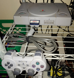A gray slab with a top-loading CD drive, and a matching gray controller with handles.