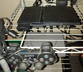 Small thin black slab, almost dwarfed by its own controller.