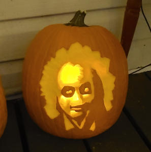 A large pumpkin with an image of Michael Keaton as Beetlejuice carved into it.