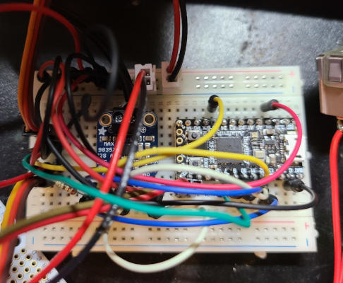 A breadboard with two small circuit boards plugged into it, and a mess of jumper wires connecting different points.