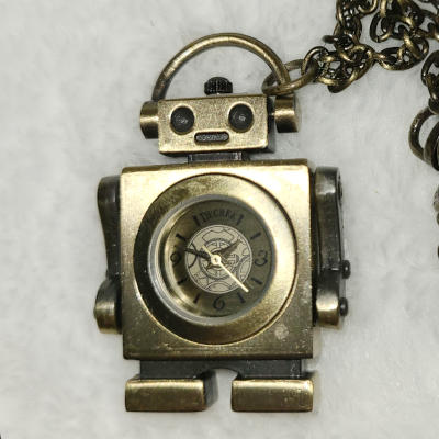 A brass-colored robot with an oblong head and a large square body. Most of the body is taken up by an analog clock face.