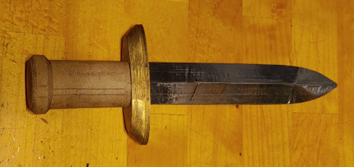 A silver dagger with a gold guard and pale wooden handle.