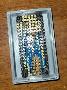 A circuit board with resistors on it, crisscrossed by thin blue wire.