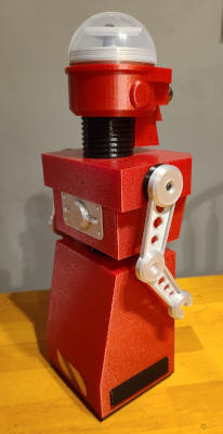 A back view of the same red robot, showing silver faux-machinery on the small of the back and a saftey stripe sticker at the bottom of the skirt.